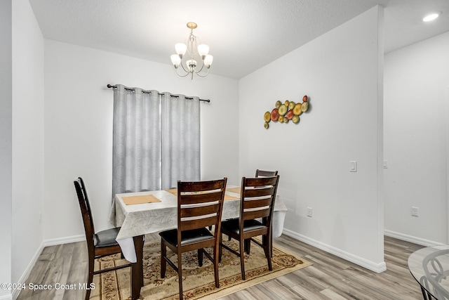 dining room with light hardwood / wood-style floors and a chandelier