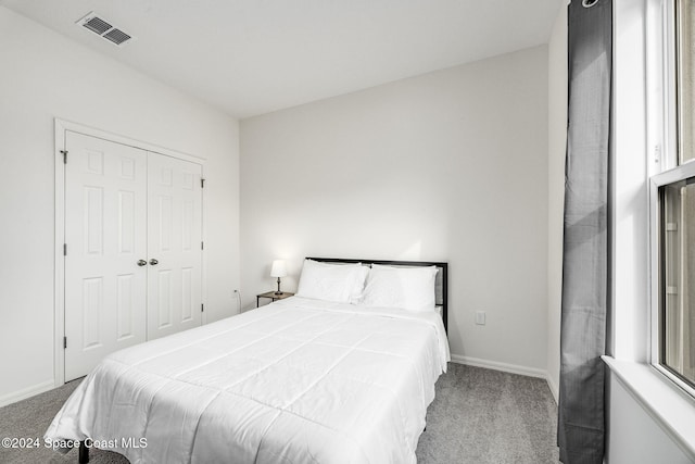 bedroom featuring a closet and light colored carpet