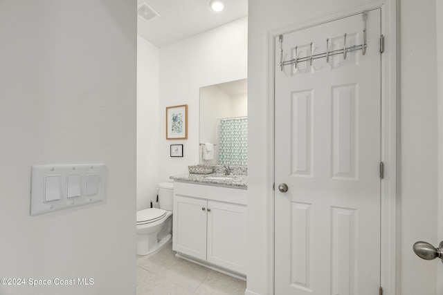 bathroom featuring curtained shower, vanity, tile patterned floors, and toilet