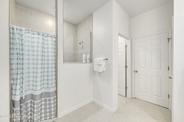 bathroom with curtained shower and tile patterned floors