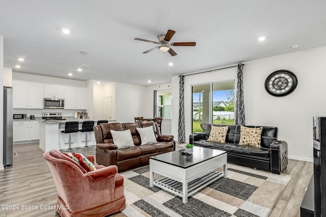 living room with ceiling fan and light hardwood / wood-style floors