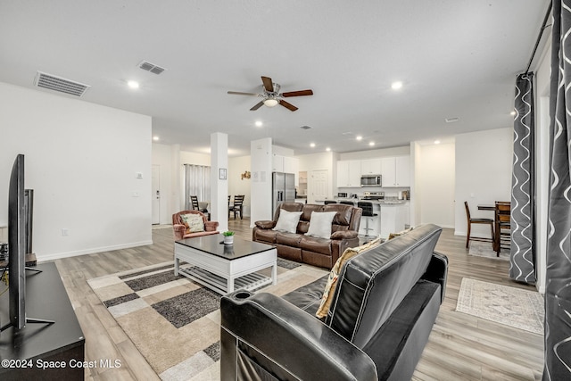 living room with ceiling fan and light wood-type flooring