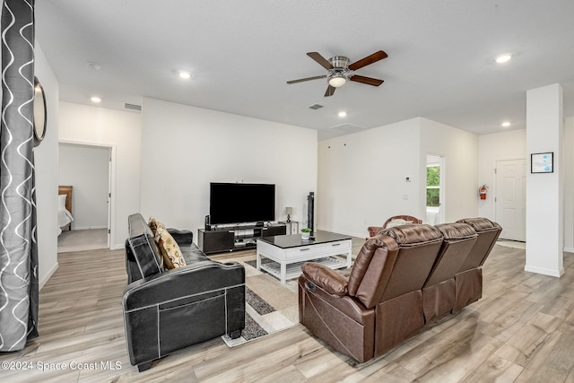 living room with ceiling fan and light hardwood / wood-style flooring