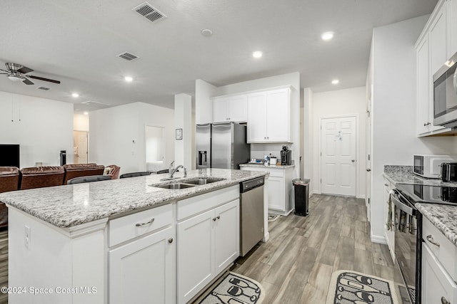 kitchen featuring light hardwood / wood-style flooring, white cabinetry, a kitchen island with sink, and stainless steel appliances