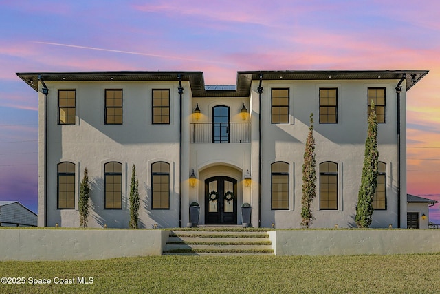 view of front of house with a yard and french doors