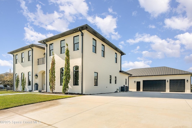 view of front of property featuring central AC, a garage, and a front yard