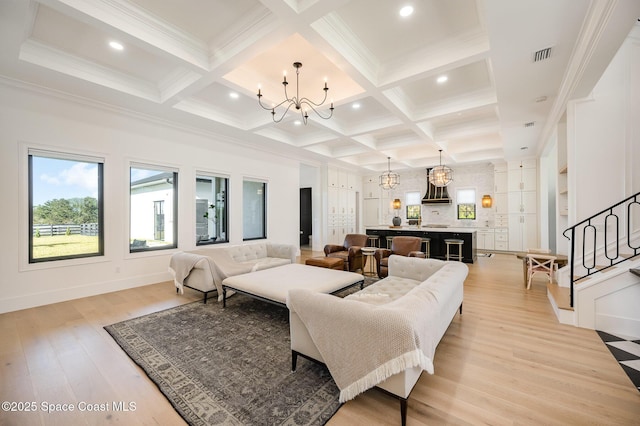 living room featuring beamed ceiling, plenty of natural light, and a notable chandelier