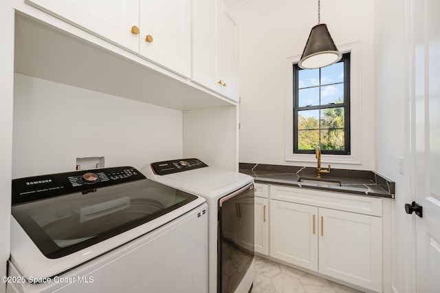 washroom featuring separate washer and dryer, sink, and cabinets