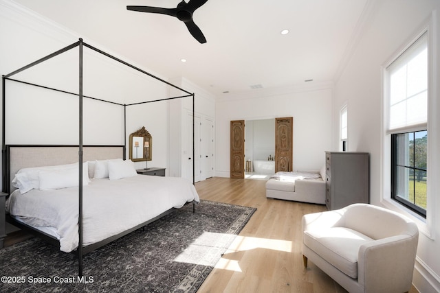 bedroom with crown molding, light hardwood / wood-style flooring, and ceiling fan