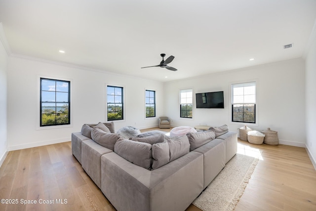 living room featuring light hardwood / wood-style flooring, ornamental molding, and ceiling fan