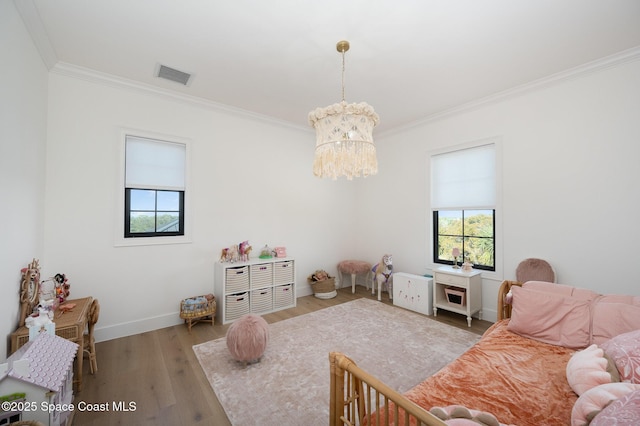 interior space featuring crown molding, wood-type flooring, and an inviting chandelier