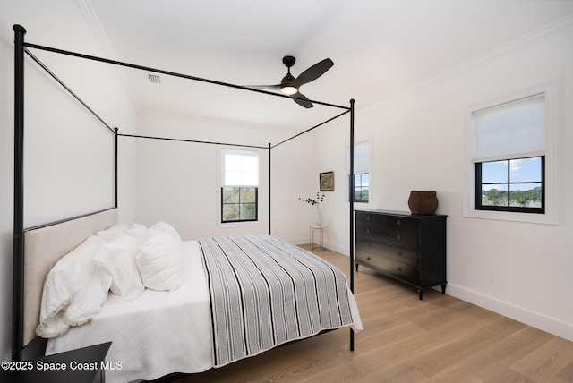 bedroom with crown molding, ceiling fan, and light hardwood / wood-style floors