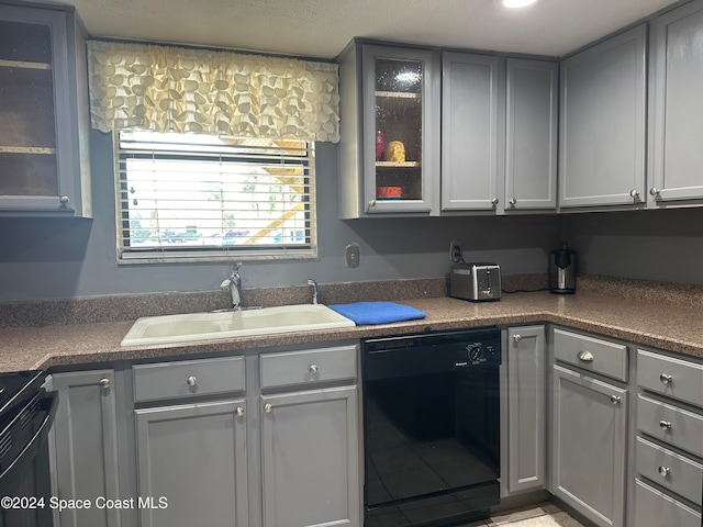 kitchen featuring dishwasher, gray cabinetry, sink, and range with electric cooktop