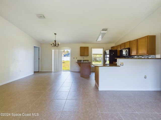 kitchen with hanging light fixtures, black appliances, light tile patterned floors, and vaulted ceiling