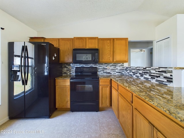 kitchen featuring black appliances, a textured ceiling, vaulted ceiling, and light tile patterned flooring