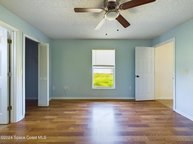 unfurnished bedroom with a textured ceiling, hardwood / wood-style flooring, and ceiling fan