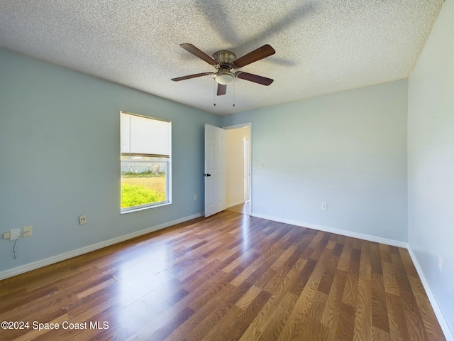 empty room with dark wood-type flooring, a textured ceiling, and ceiling fan