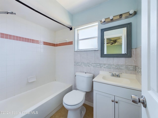 full bathroom with tile walls, vanity, tiled shower / bath combo, tile patterned flooring, and toilet