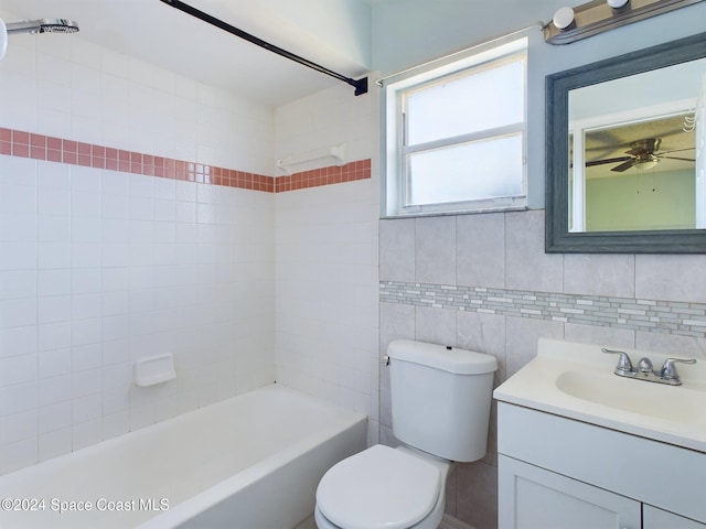 full bathroom with toilet, vanity, tile walls, and tiled shower / bath