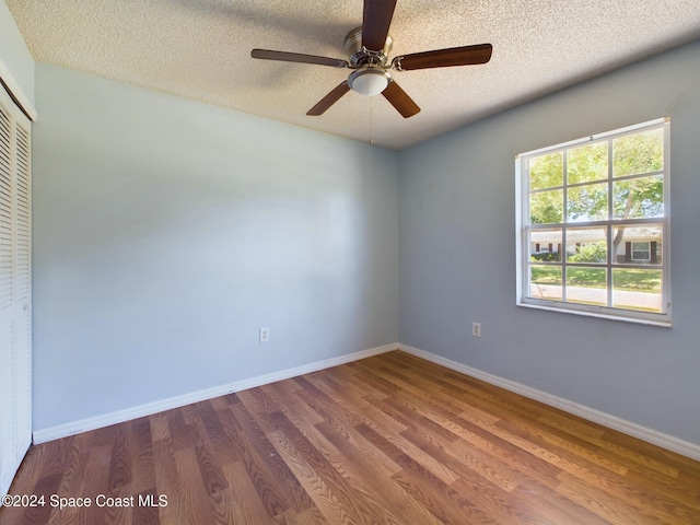 spare room with ceiling fan, wood-type flooring, and a textured ceiling