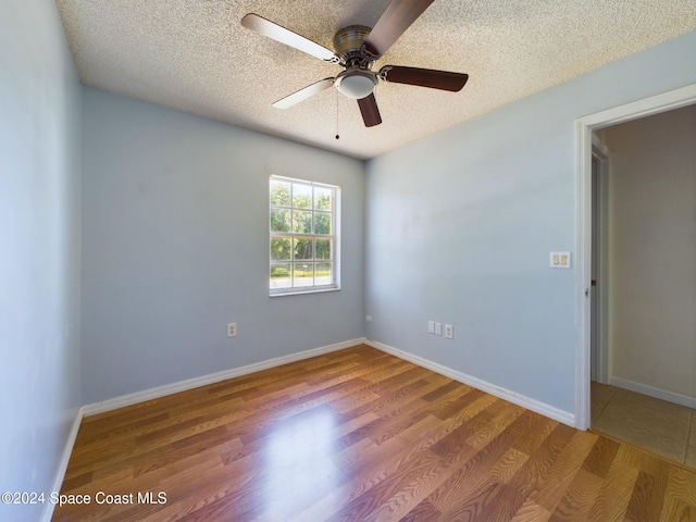 spare room featuring hardwood / wood-style floors, ceiling fan, and a textured ceiling