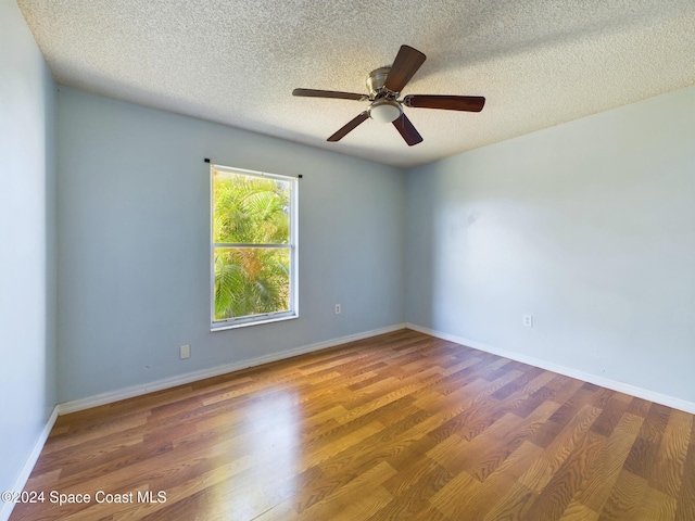 spare room featuring a textured ceiling, dark hardwood / wood-style floors, and ceiling fan