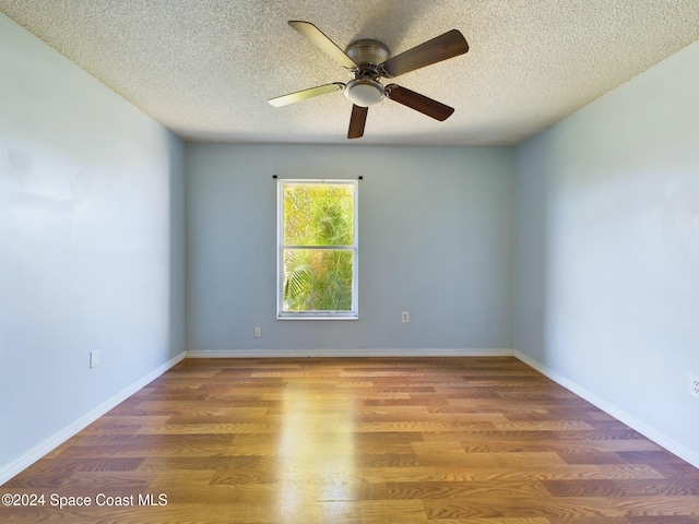 empty room featuring ceiling fan, wood-type flooring, and a textured ceiling