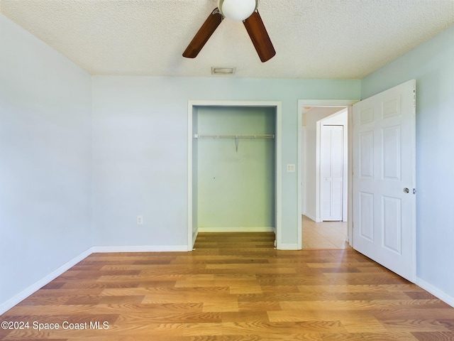 unfurnished bedroom with a textured ceiling, wood-type flooring, and ceiling fan