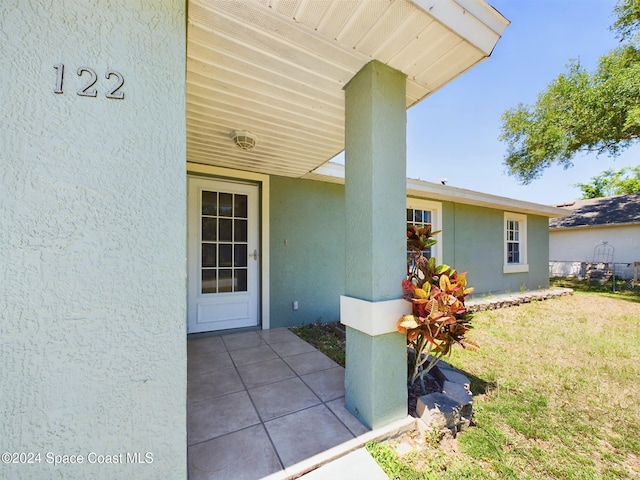 property entrance featuring a lawn