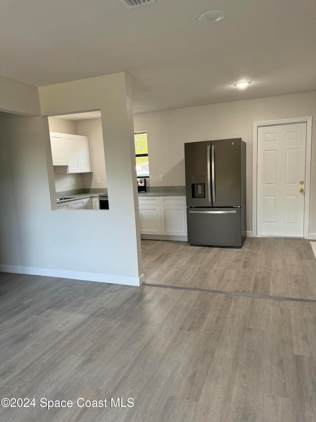 kitchen with white cabinetry, light hardwood / wood-style flooring, and stainless steel refrigerator with ice dispenser