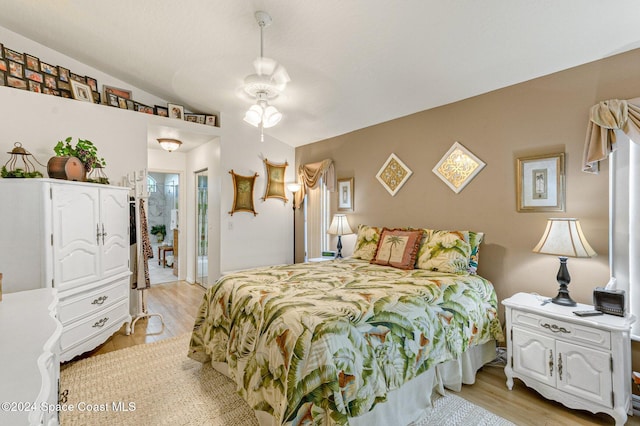 bedroom featuring ensuite bathroom, light hardwood / wood-style flooring, lofted ceiling, and ceiling fan