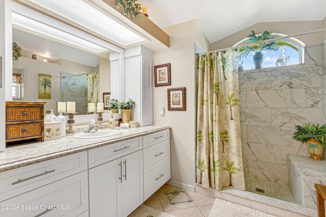 bathroom featuring a shower with curtain, vanity, lofted ceiling, and tile patterned flooring