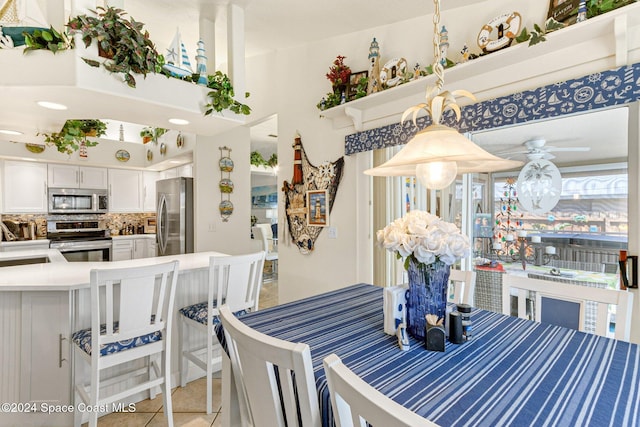 tiled dining area with sink and ceiling fan