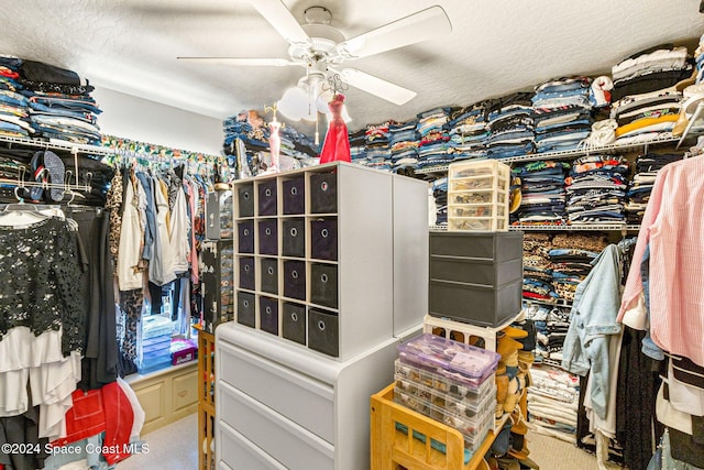 spacious closet with light colored carpet and ceiling fan