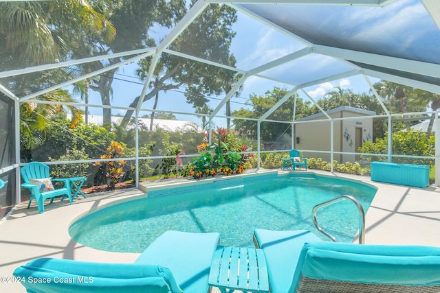 view of pool with glass enclosure and a patio area