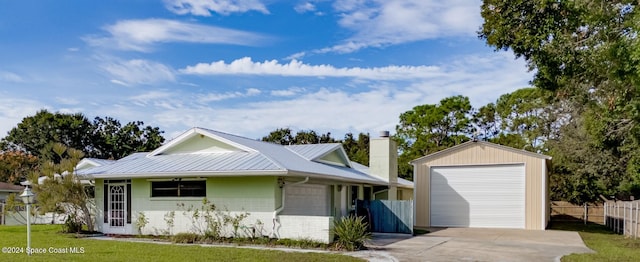 view of front facade featuring a front yard, a garage, and an outdoor structure