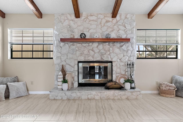 living room featuring a textured ceiling, a fireplace, plenty of natural light, and beamed ceiling