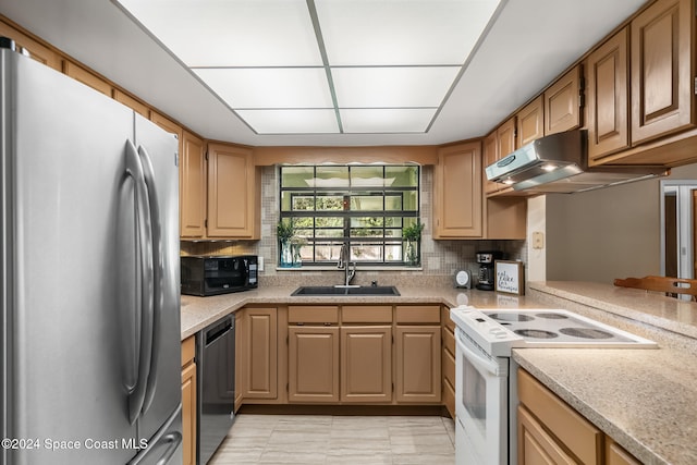 kitchen featuring stainless steel appliances, sink, backsplash, and kitchen peninsula