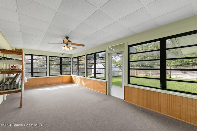 unfurnished sunroom featuring plenty of natural light, a paneled ceiling, and ceiling fan