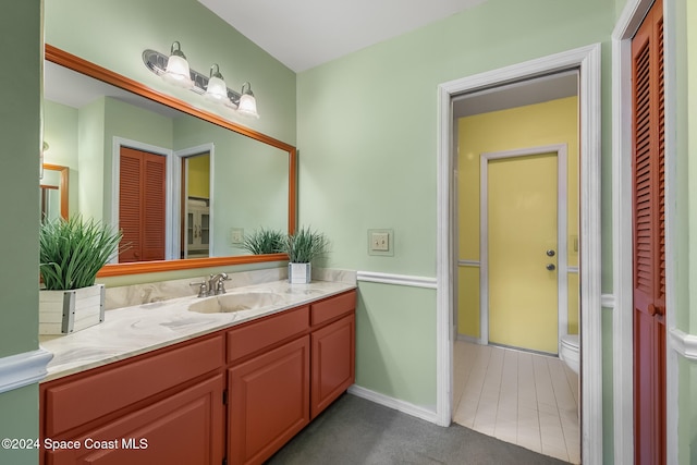 bathroom with tile patterned flooring, vanity, and toilet