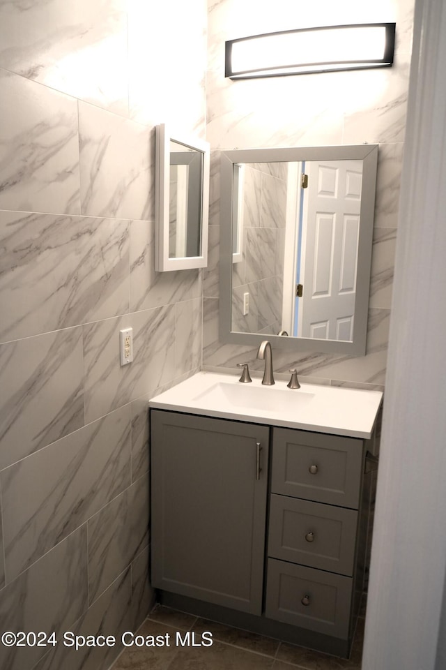 bathroom with vanity and tile walls