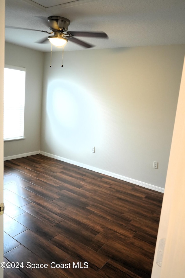 unfurnished room with dark hardwood / wood-style flooring and ceiling fan