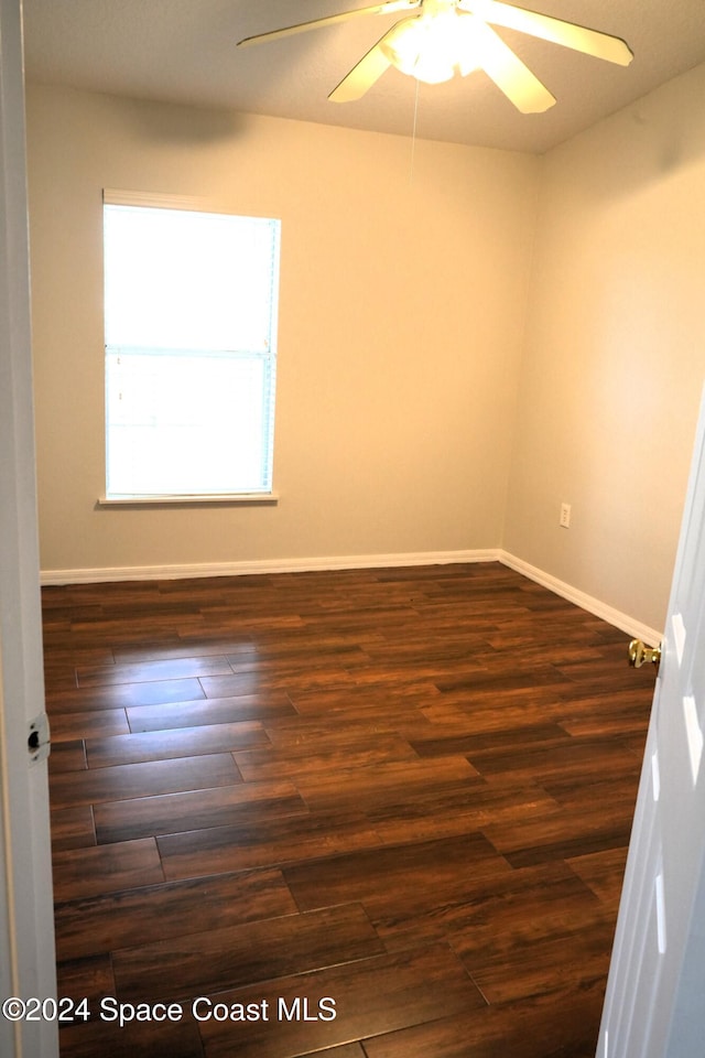 spare room featuring dark hardwood / wood-style flooring and ceiling fan