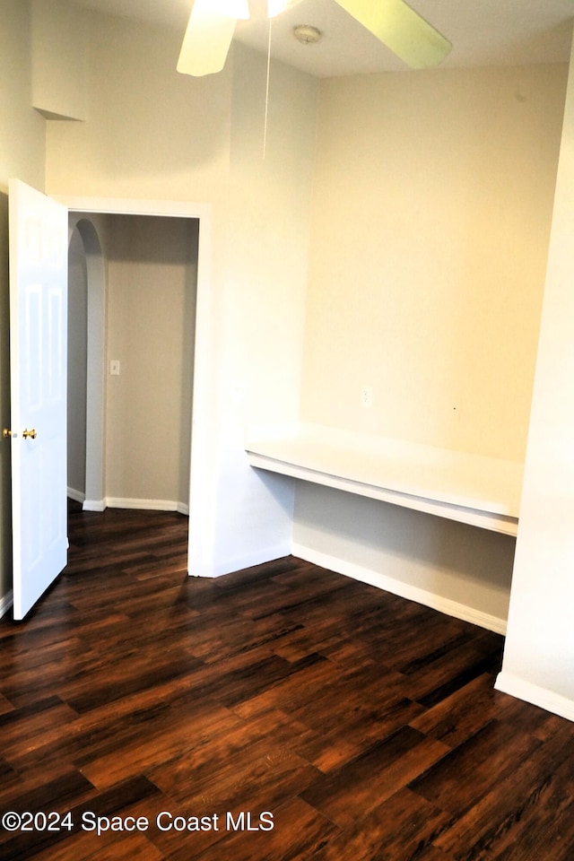 empty room with dark wood-type flooring and ceiling fan