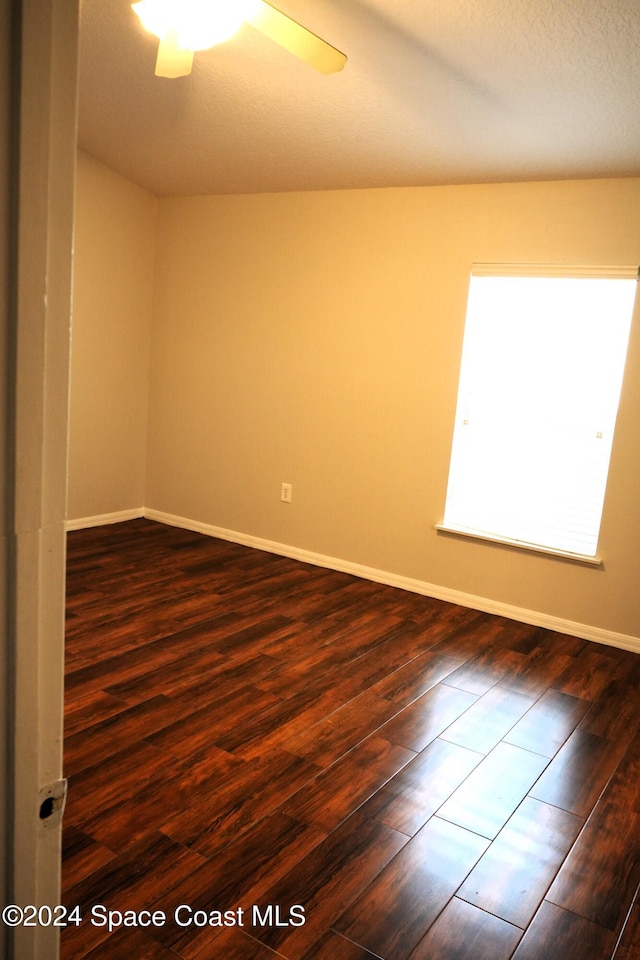 empty room with ceiling fan and dark hardwood / wood-style floors