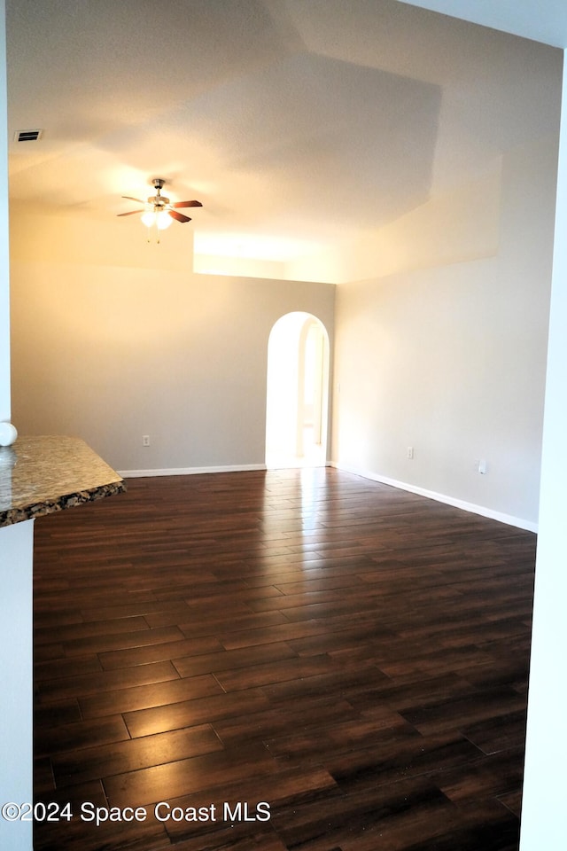 spare room featuring dark wood-type flooring and ceiling fan