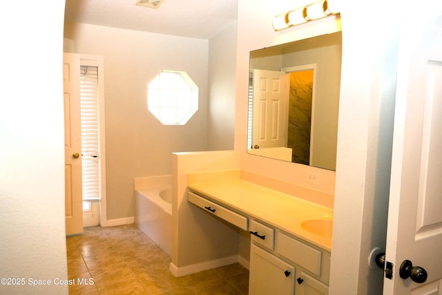 full bathroom with a bath, tile patterned flooring, vanity, and baseboards