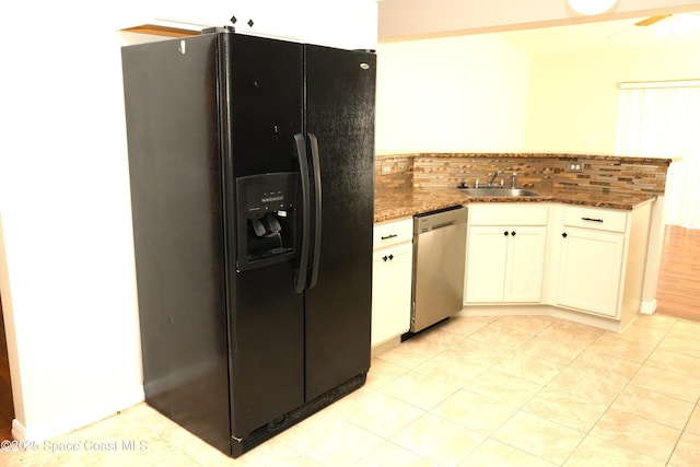 kitchen with stone counters, a peninsula, a sink, stainless steel dishwasher, and black fridge