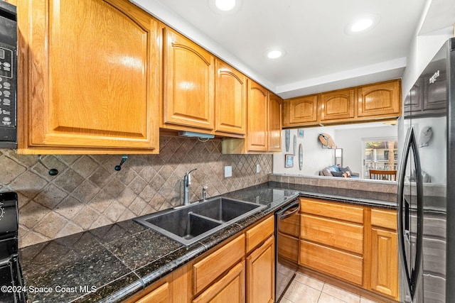 kitchen with dishwasher, decorative backsplash, sink, light tile patterned floors, and fridge