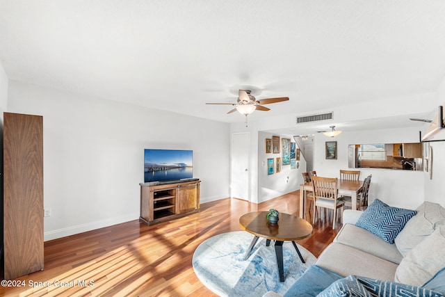 living room featuring ceiling fan and wood-type flooring